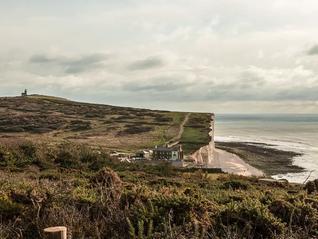 Looking down to Birling Gap within the undulating clifftops on the walk towards Friston Forest. Belle Tout Lighthouse is visible in the distance.