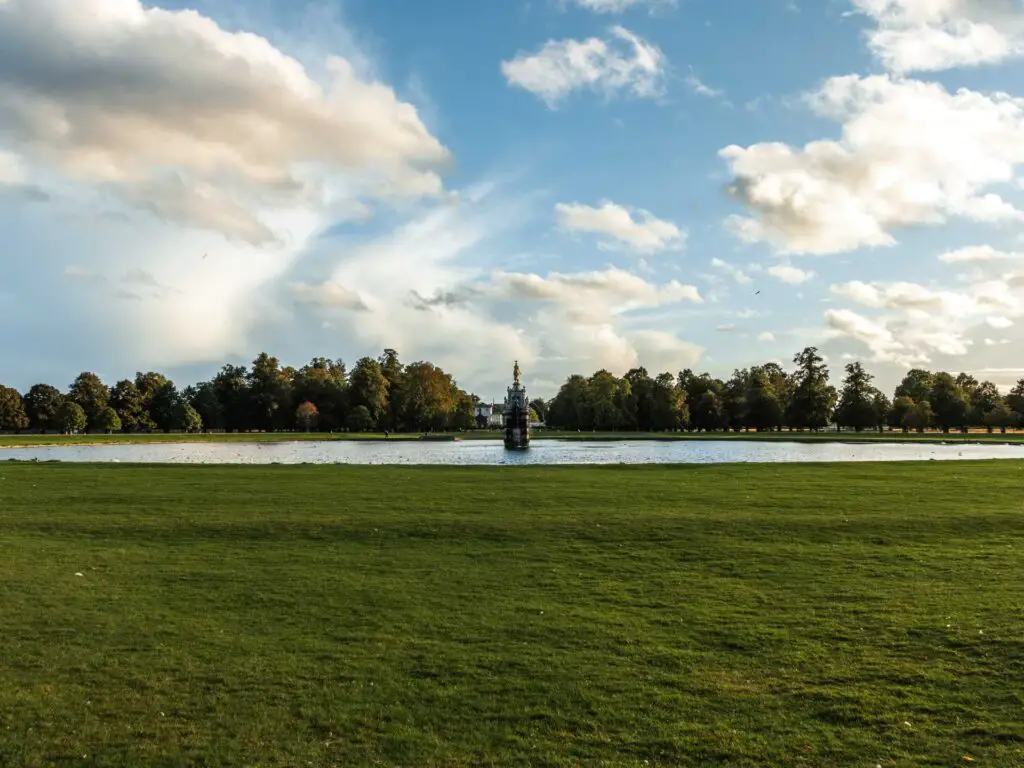 Looking across the well manicured grass to the Diana fountain and pond on the walk through Bushy park. There are lots of trees on the other side.