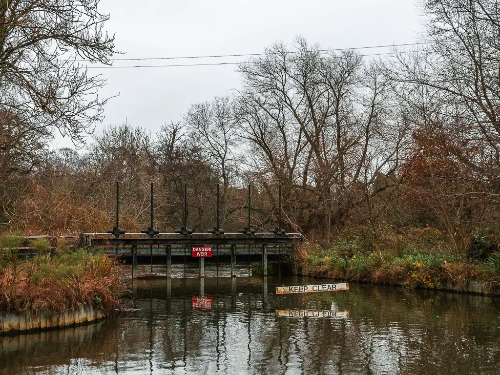 A keep clear and danger sign on the weir on the water.