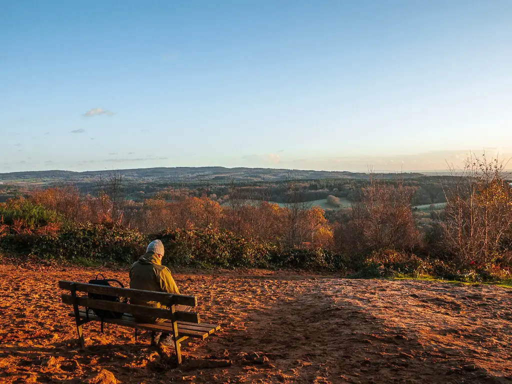 A man sitting on a bench on the sandy St Martha's Hill top on the walk back from Newlands Corner. 