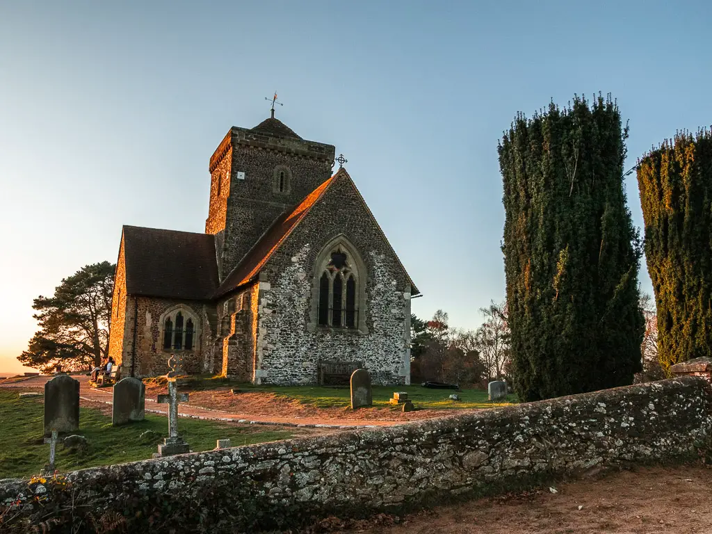 A church and graveyard on the other side of a stone wall on one of the walks around Guidlford. 