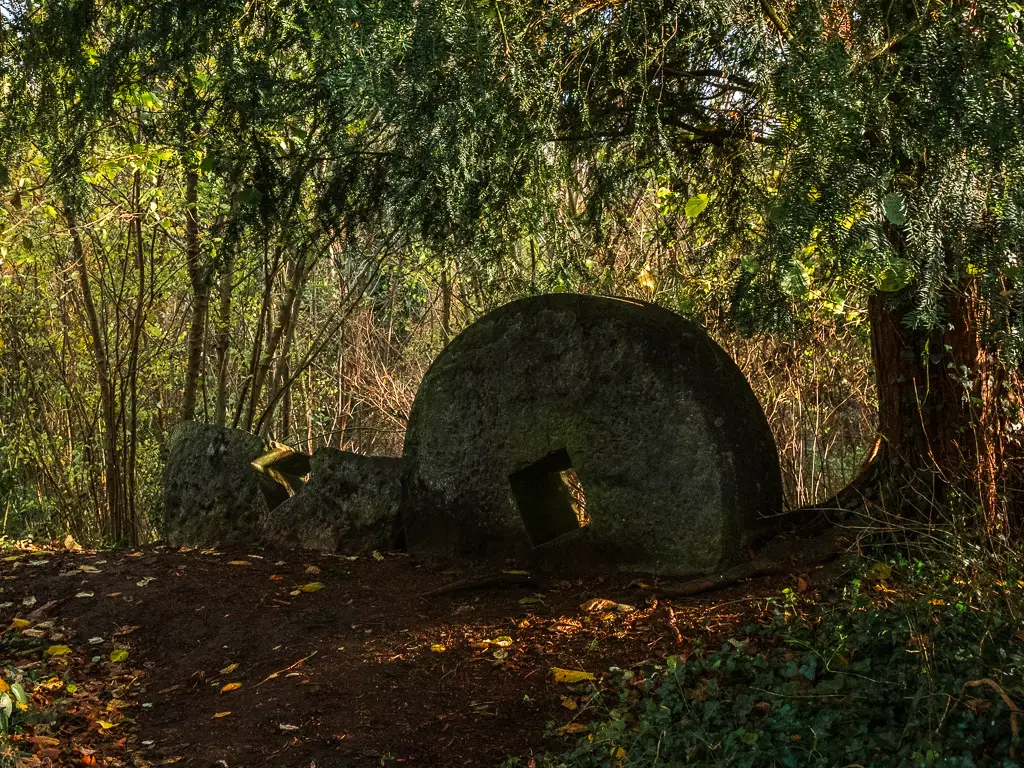 The remains of edge runner mill stones under the tree on the walk through the Chilworth Gunpowder mills.