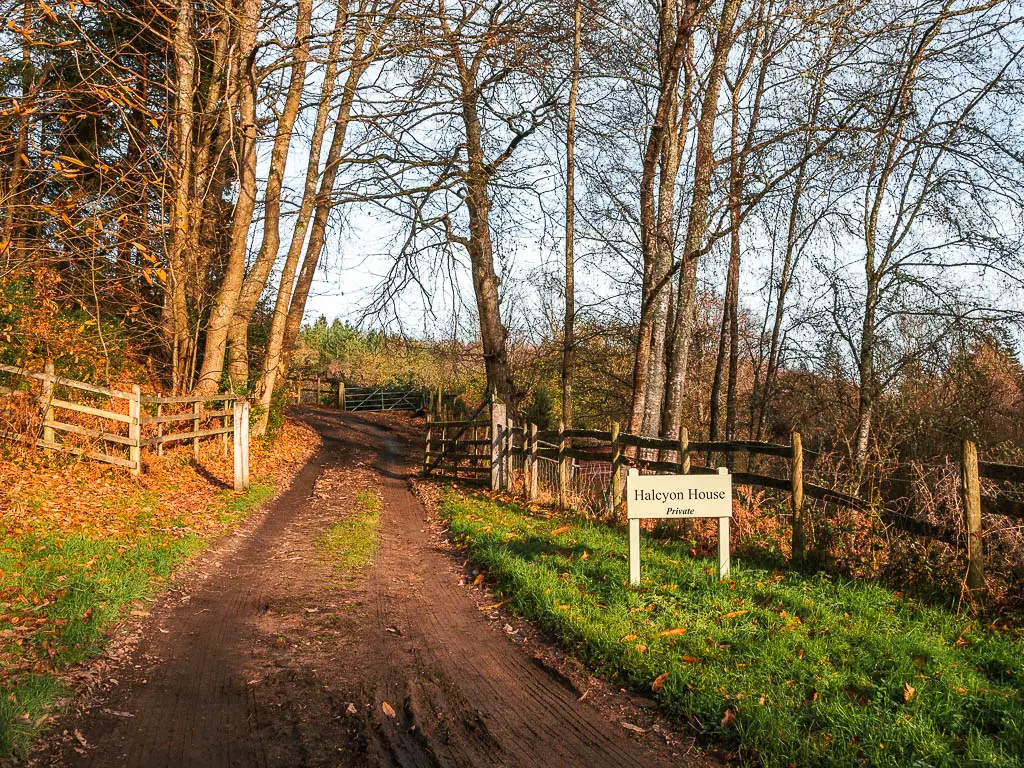 A dirt road leading through a wooden gate. There is a sign that says 'private'.