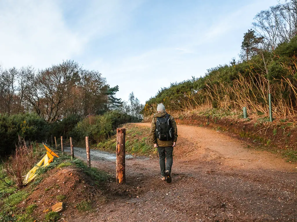 A man walking on the left trail of a split junction.