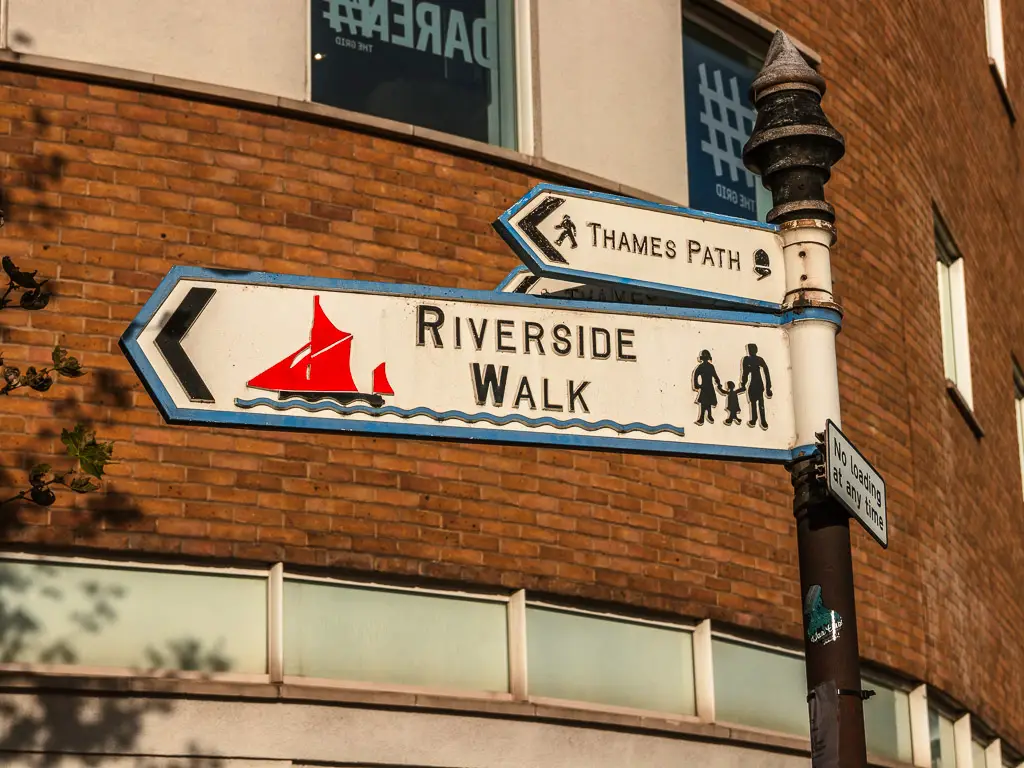 Riverside walk signpost pointing the way fro the Thames Path on the walk from Putney to Battersea.