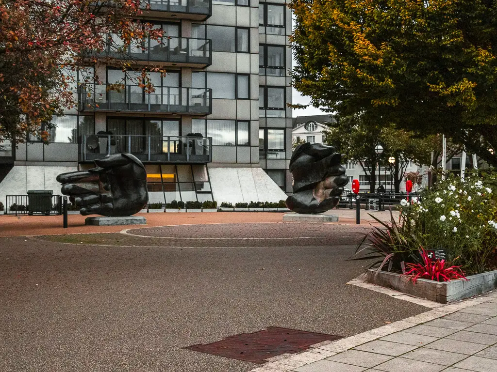 Giant hand sculptures in front of an apartment block on the Thames Path walk from Putney to Battersea. 