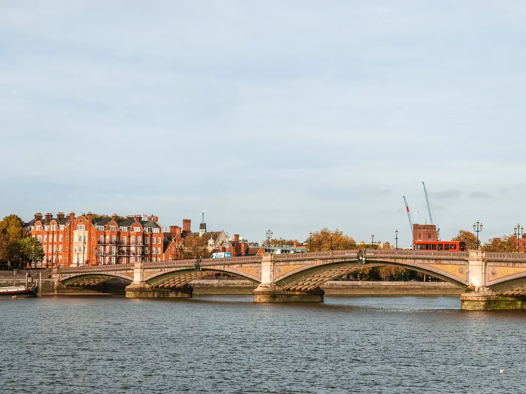 Batrersea Bridge over the river Thames, on the walk from Putney. There is a red bus going across the bridge. 