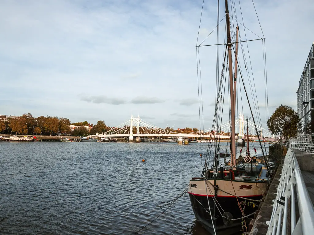 A ship on the edge of the River Thames, with Albert Bridge visible in the distance. 