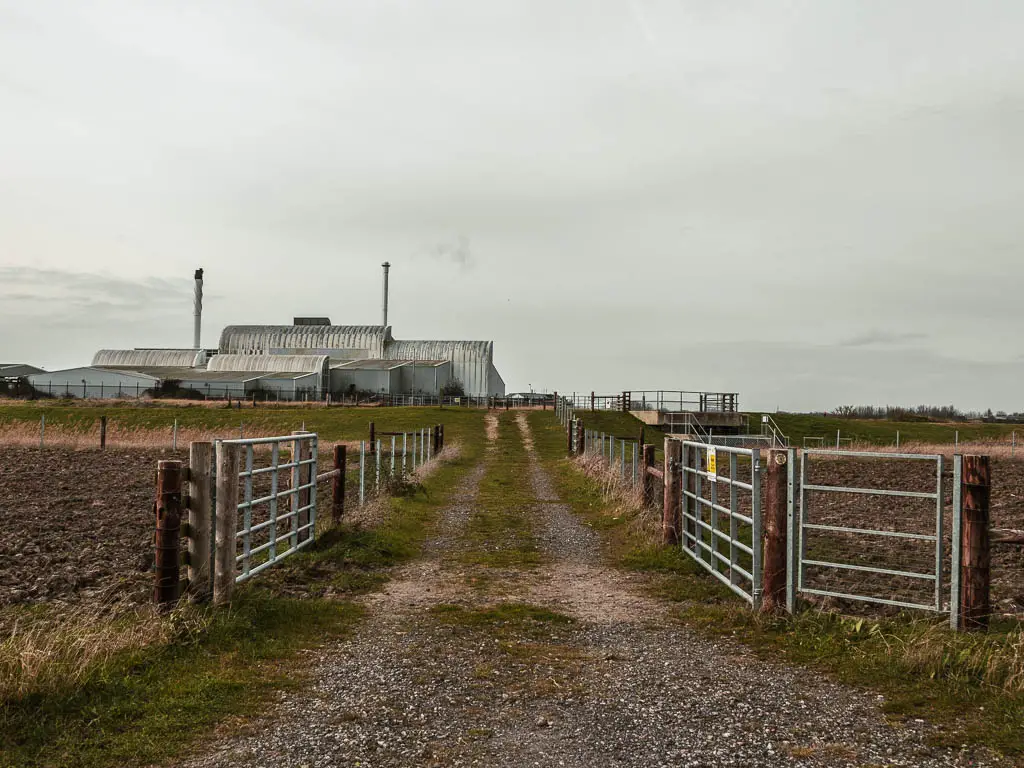 A gravel path leading up to an industrial building. 