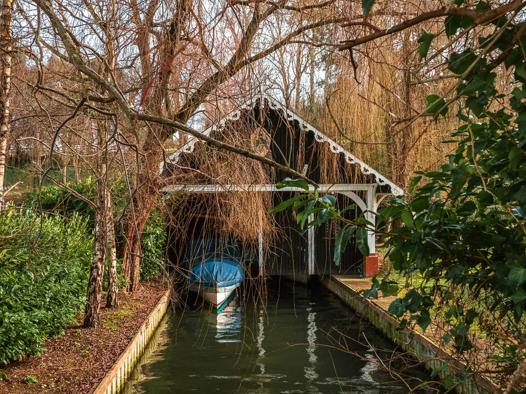 A boat garage with an A frame roof and a boat poking out. 