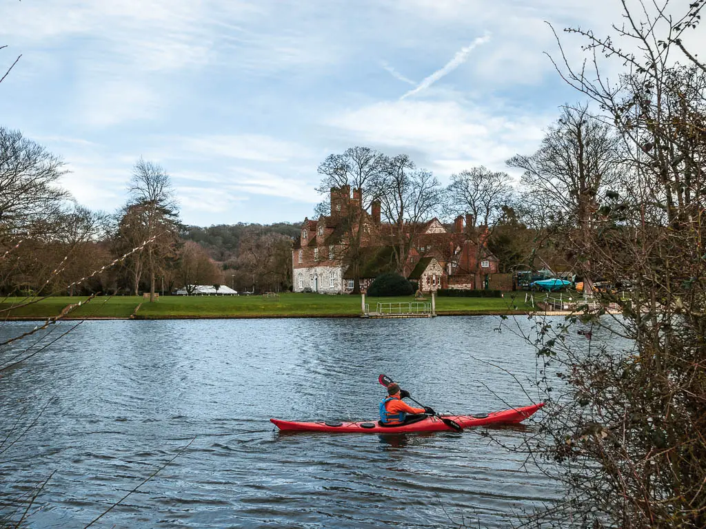 A kayaker in red on the River Thames, on the walk from Henley to Marlow. 