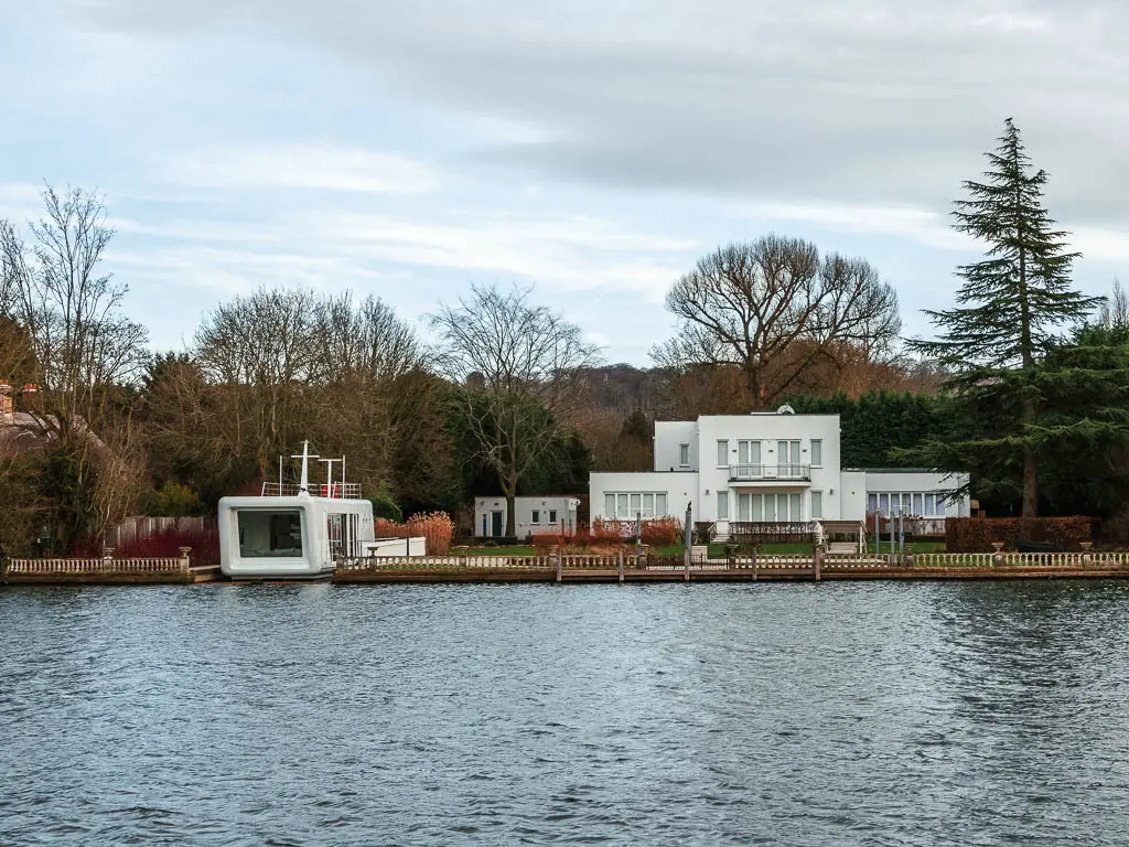 A white coloured house with a white pod on the other side of the River Thames at the end of the walk from Henley to Marlow. 