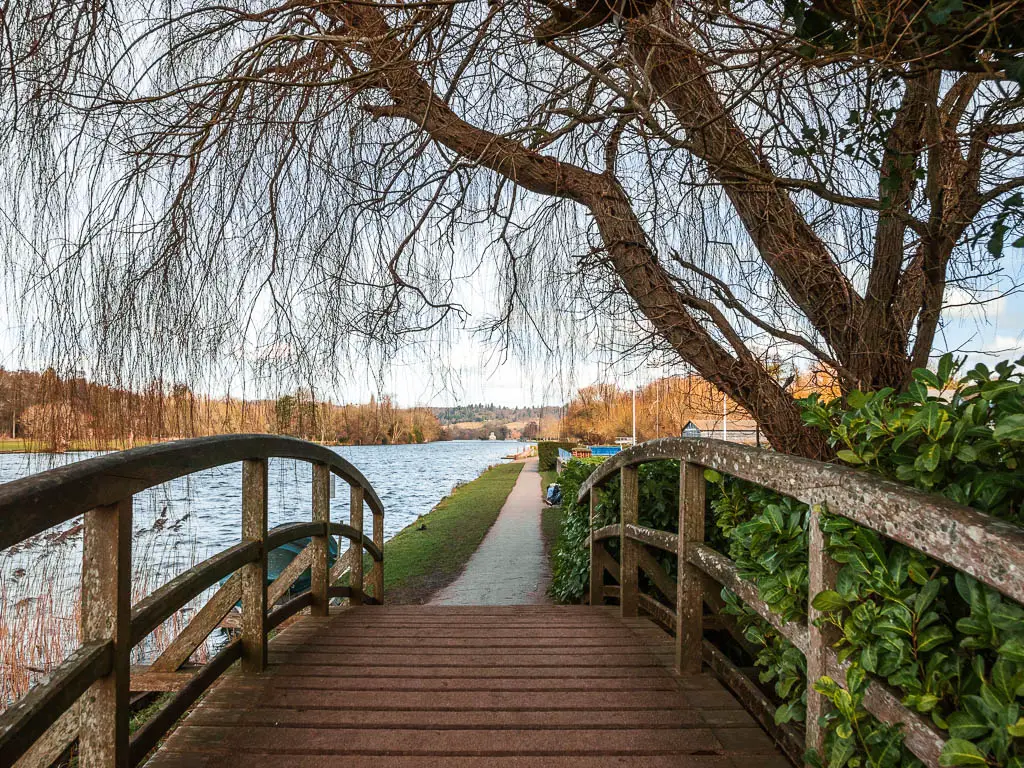 Looking along the wooden bridge with wooden railings to the Thames Path on the other side on the walk from Henley to Marlow. 