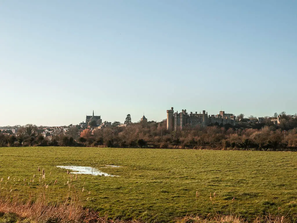 Arundel Castle across the green grass field at the end of the walk from Amberley.