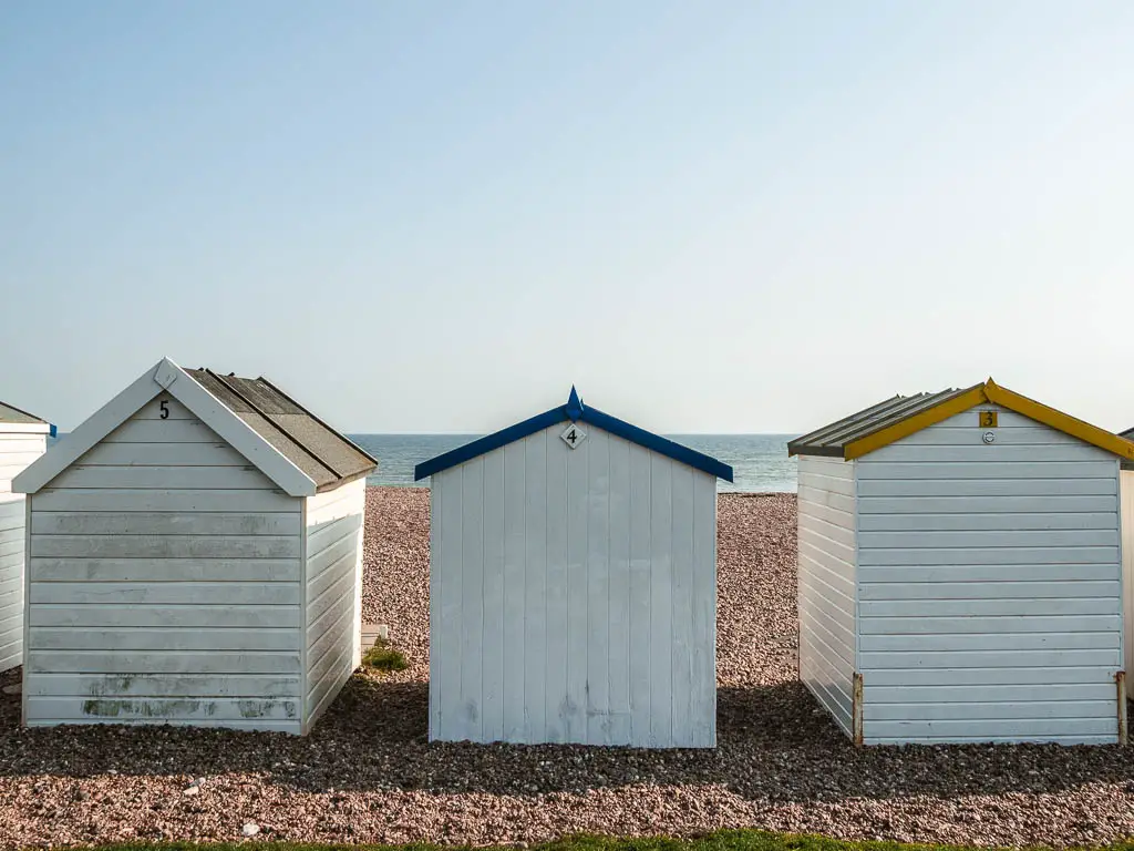 White beach huts on the shingle beach on the walk into Worthing.