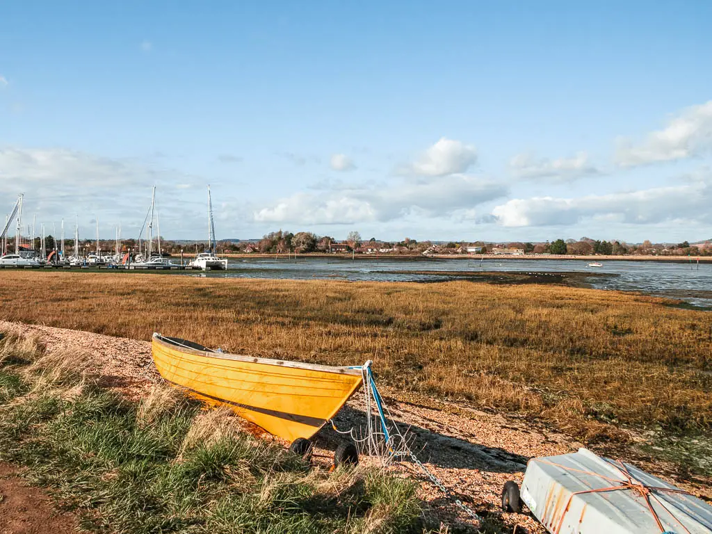 A yellow boat resting on the grown during low tide.