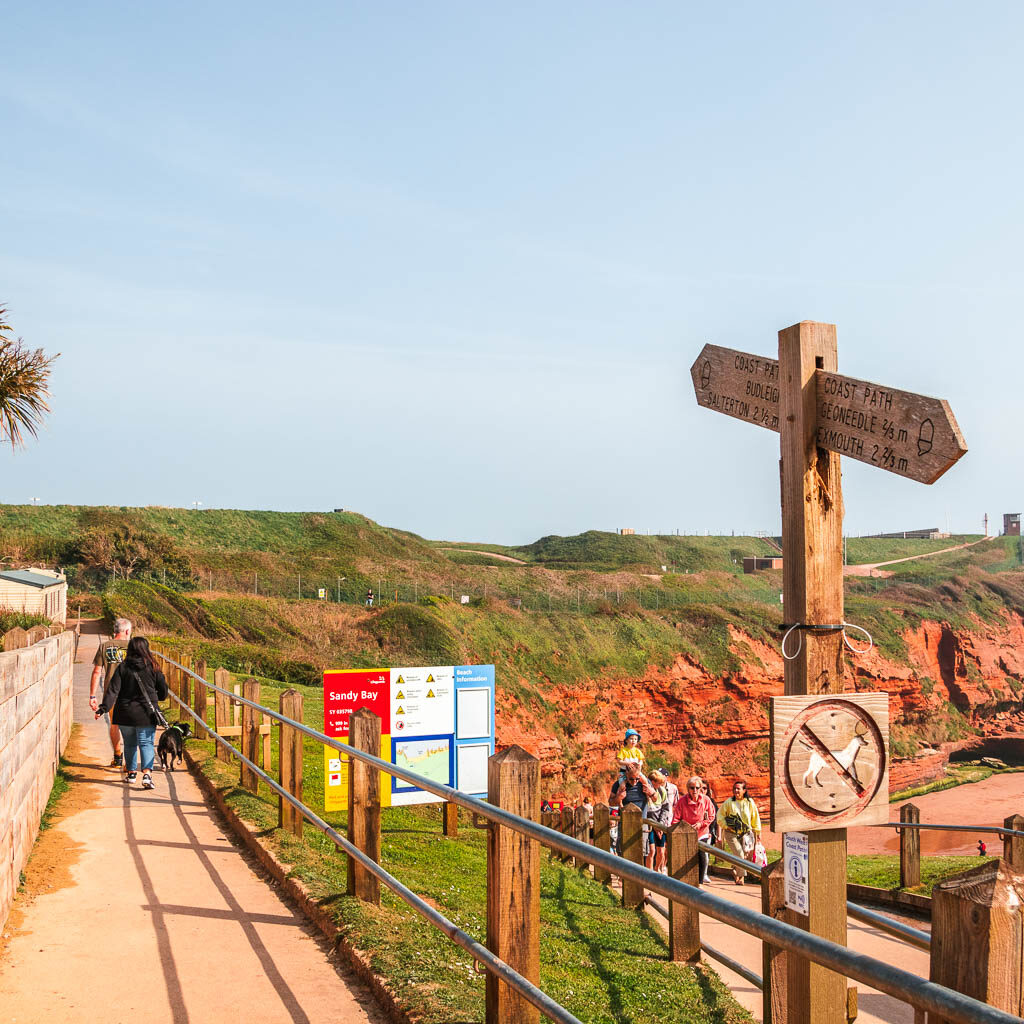 A path on the left, and railings and signpost on the right. 