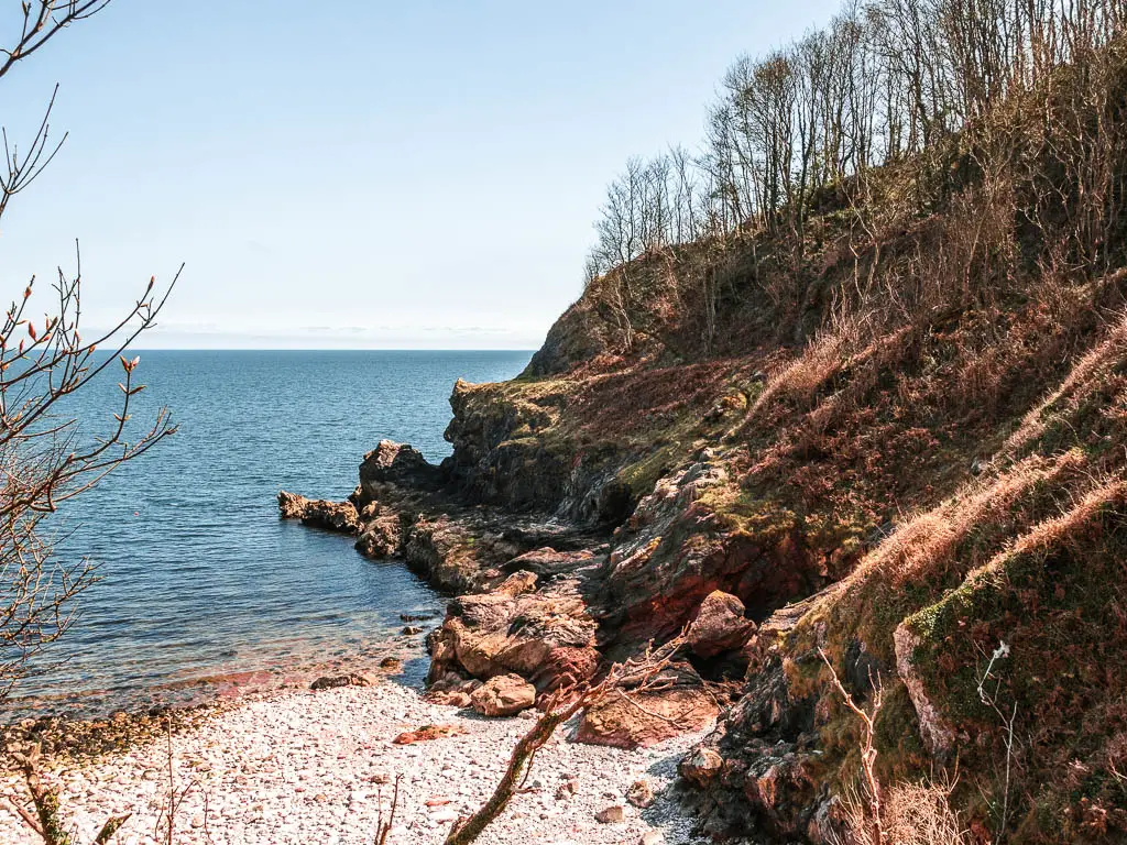 The rugged cliffside leading to a pebble beach on the coastal walk from Babbacombe to Teignmouth.