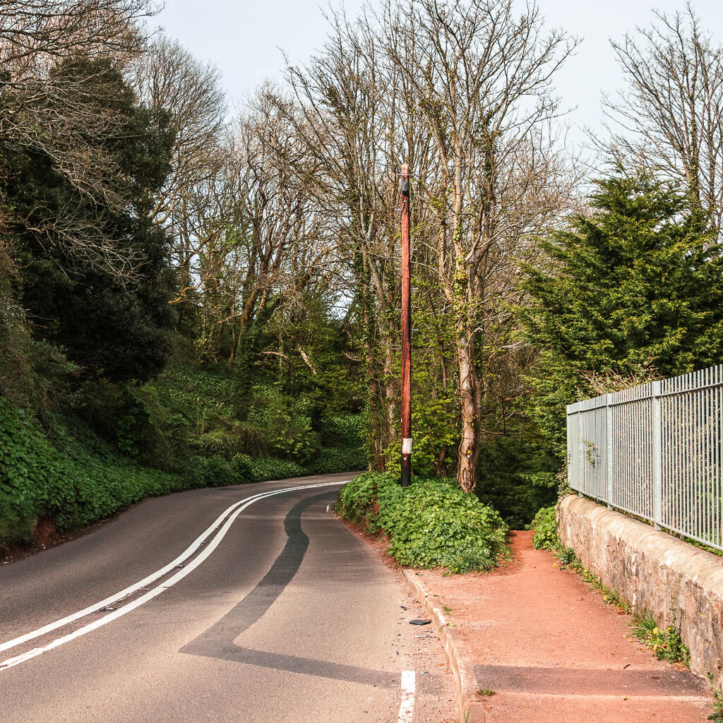 A winding road on the left and pavement and path on the right.