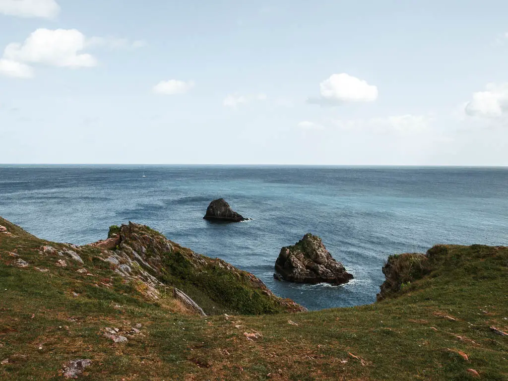 Looking across the green out to sea and a couple of sea rocks.