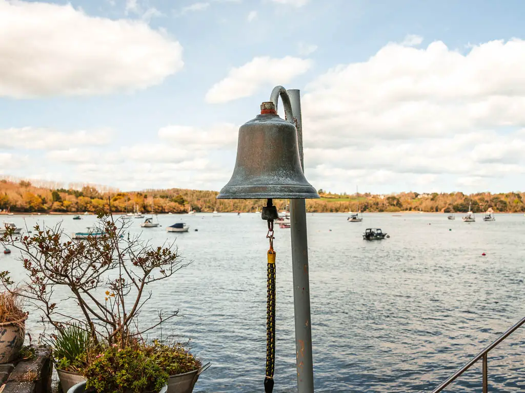 A large bell with the River Dart as a backdrop at Greenway, on the Dartmouth Dittisham circular walk.