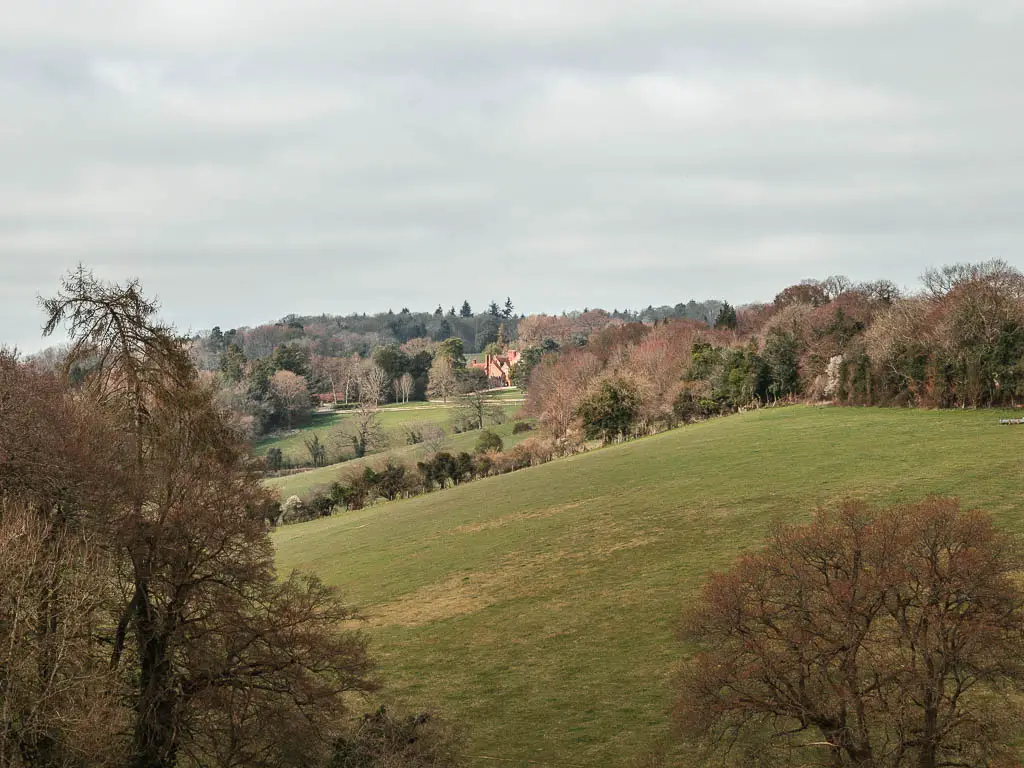 Looking across the green chiltern hills, to Greys Court nestled in the trees in the distance on the circular walk from Henley-on-Thames.
