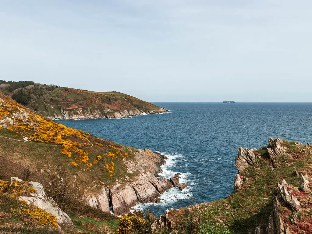 Looking down to the rugged cliffs to the left, right and ahead as the meets the blue sea on the coastal walk from Kingswear to Brixham.