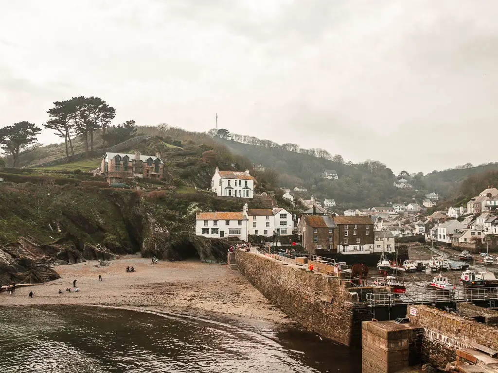 The small sandy bay of Poplerro, with the village hoses to the left and up the hill ahead, on the walk from Looe. Its a foggy misty day.