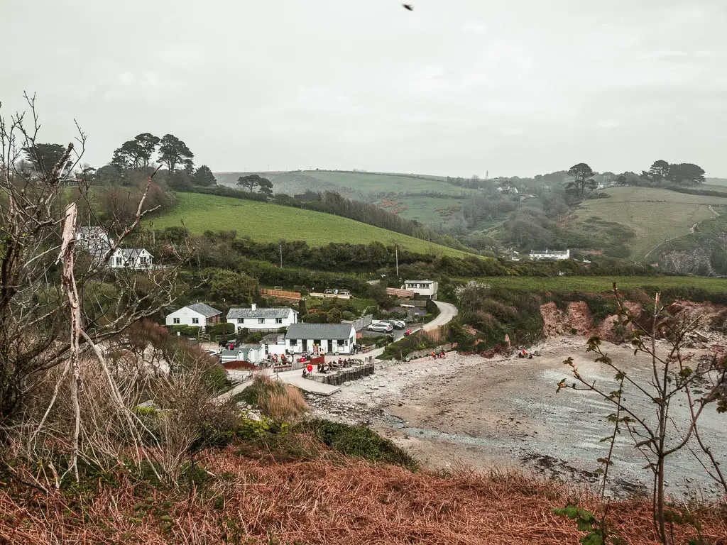 Looking down the Talland Bay cove, with a sandy beach and a small cluster of cottages.