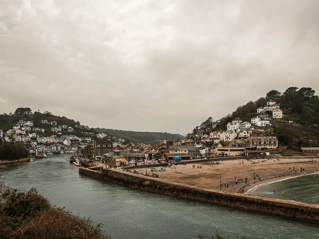 Looking along the Looe estuary at high tide at the end of the walk back from Polperro. Looe Beach is to the right, and there are houses on the hills on the right and left side of the estuary.