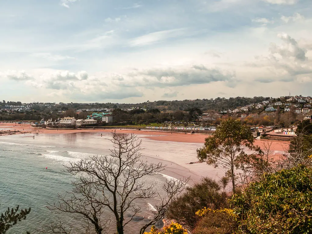 Looking down to the red sand beach of Goodrington Sands where it meets the sea on the coastal walk from Paignton to Brixham.