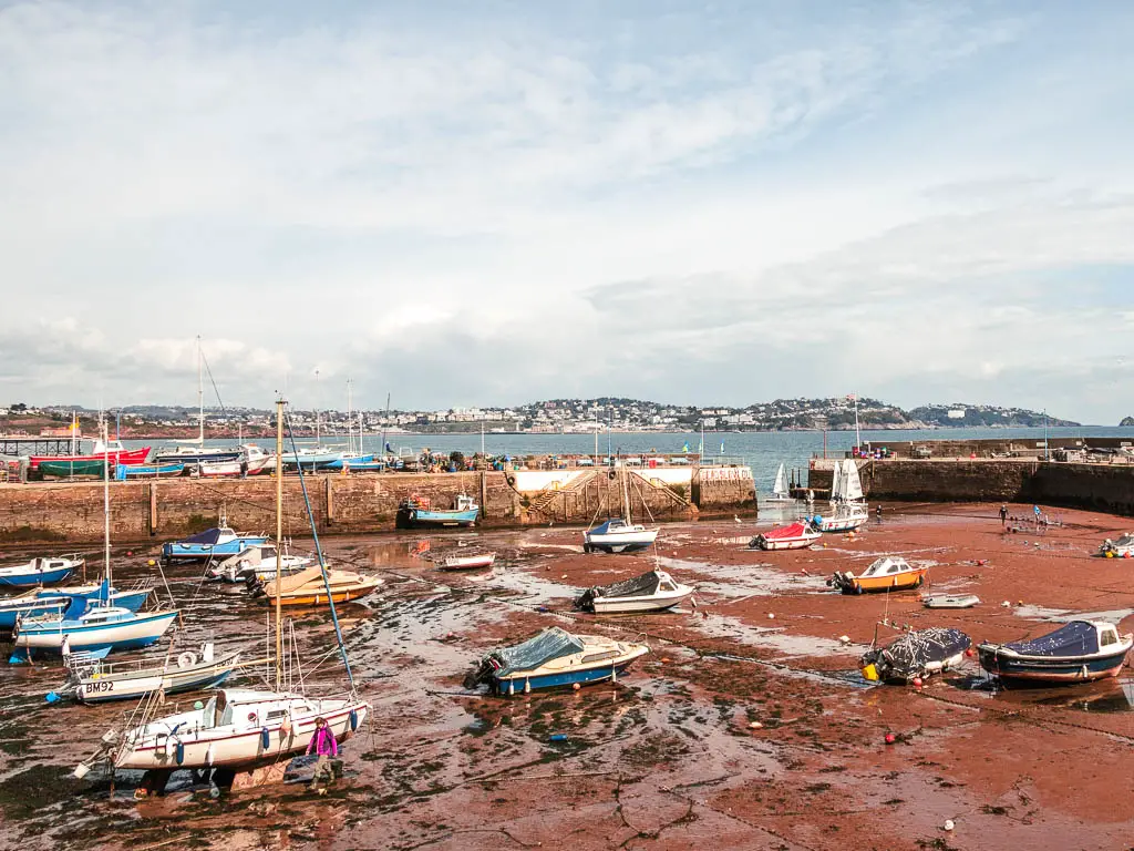 Lots of boats in the harbour on the sea bed at low tide at the start of the coastal walk from Paignton to Brixham.