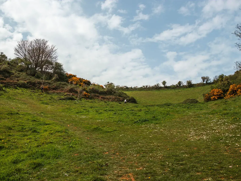 Looking up the grass hill. There is a small person visible part way up.