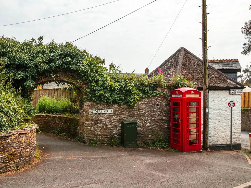 A tone and flint walk with an archway opening, and a red telephone box on the right.