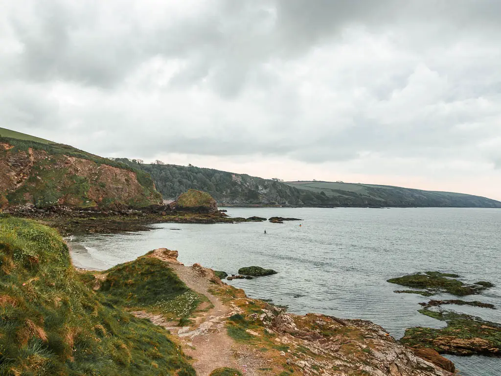 Looking across the rocky, rugged ground and out to sea and the coastline ahead on the walk from Par to Fowey. 