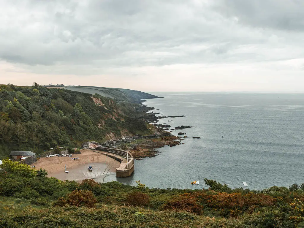 Looking down to a small cove surrounded by tree covered cliffs on the walk from Par to Fowey.