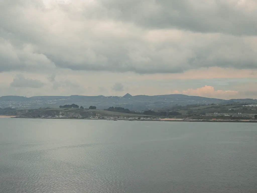 Looking across the sea to land on the other side. Everything thing is misty and grey.