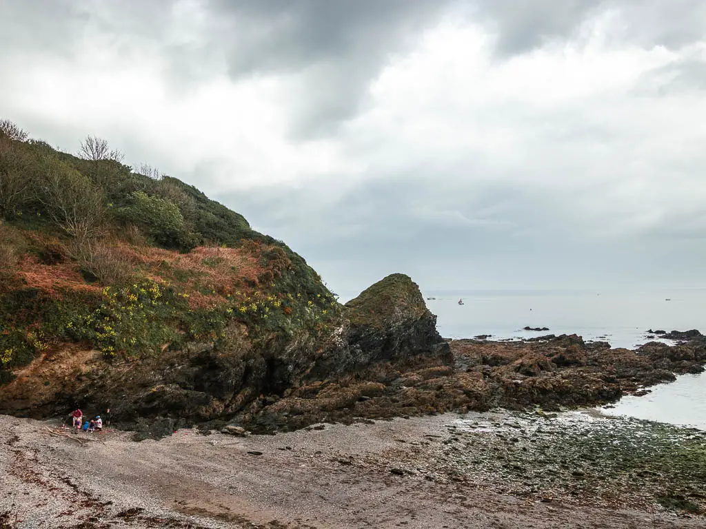 A beach cove with jagged rocks on the other side.