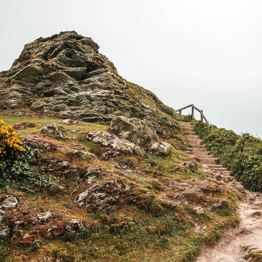 A rocky tor outcrop on the left, and some steps on the right.