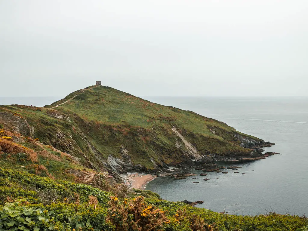 Looking across the the Rame Head Peninsular on the walk from Kingsand. The peninsular forms a cove with a small beach, and there is a small church on the top of the hill.