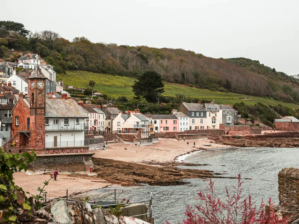 Looking down to the cove of Kingsand and the start of the walk to Rame Head. the cove has a sandy beach and lots of pastel coloured houses on the shore line. 