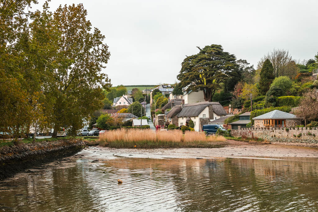 The end of the river with a cluster of houses and thatched roofed cottaged on the bank, along the walk from Salcombe to Snapes Point. 