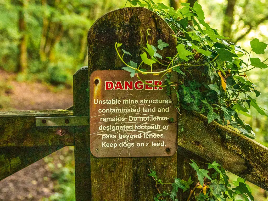 A wooden gate with a sign warning of danger.