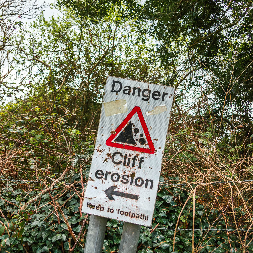 A danger sign warning of cliff erosion. 