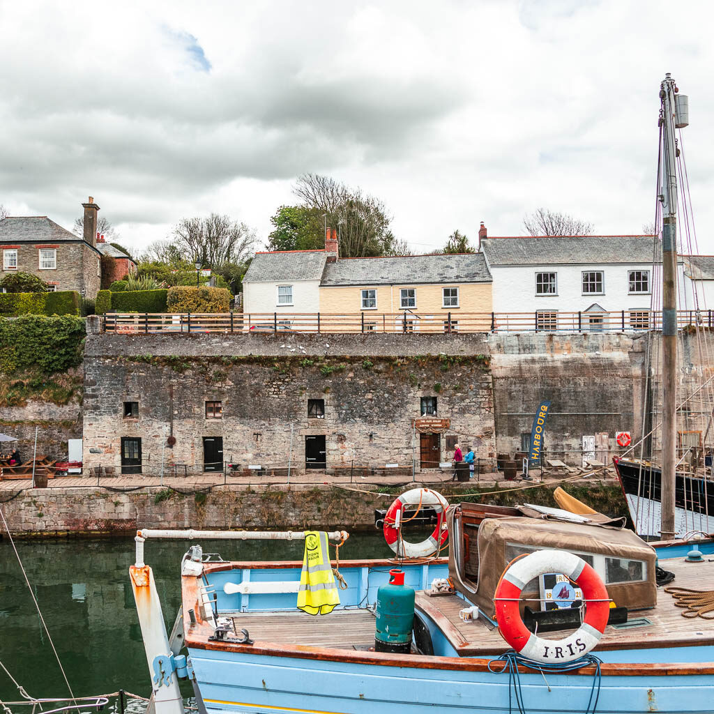 Looking across the top of a big boat to an old building on the other side of the harbour.