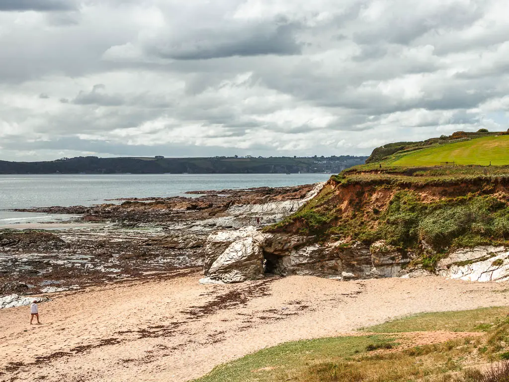 Looking down to Spit Beach Par, on the coastal walk from Charlestown. It is a sandy beach, and there are sliver coloured rocks  by the cliff.