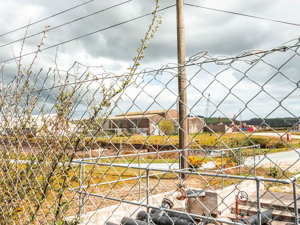 Looking through the metal fence to an industrial estate.