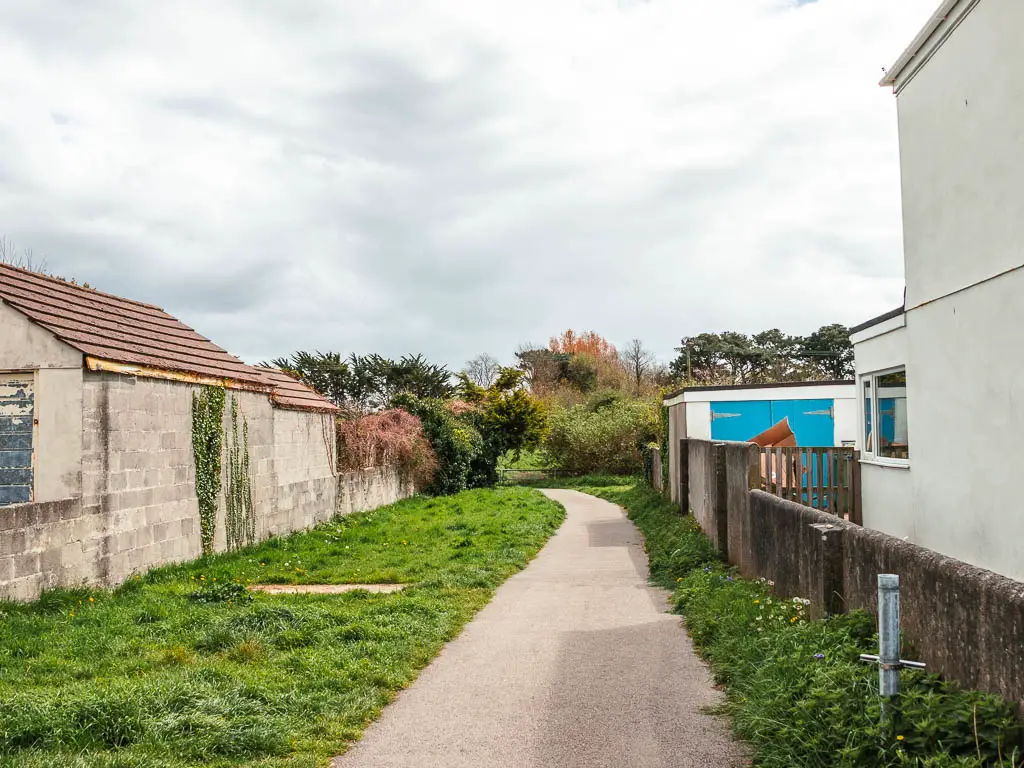 A wide path running between the houses, lined with grass.