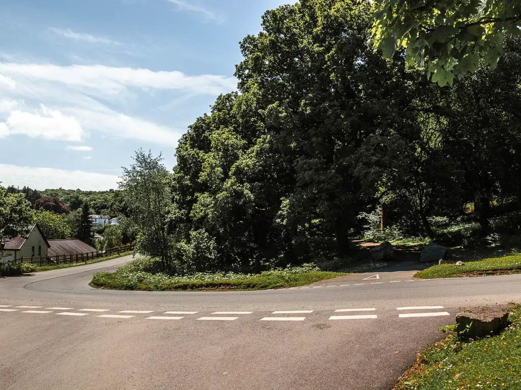 Looking across the road to the green with trees on the other side.