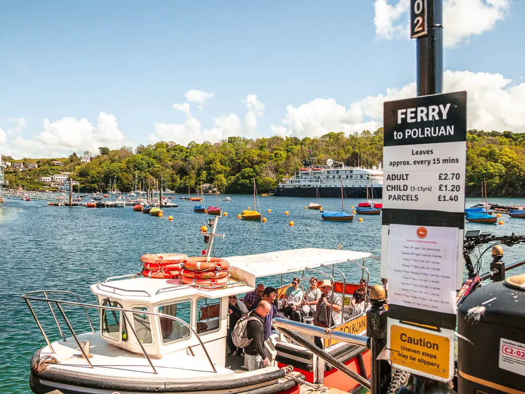 The Fowey to Polruan ferry boat moored at the side with people getting off.